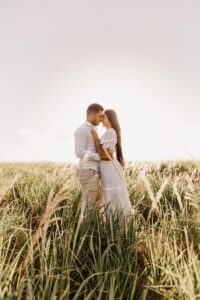 Young couple in love embracing in a sunny meadow, symbolizing romance and connection.